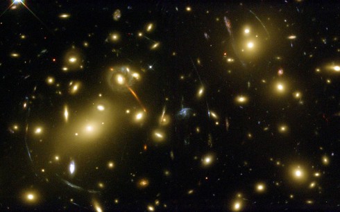 Příroda astronomům nabídnula unikátní možnost, jak nahlédnout do skutečně hlubokého vesmíru. Ocitne-li se totiž mezi námi a vzdáleným kosmickým objektem bližší galaxie nebo kupa galaxií, může dojít k zakřivení záření vysílaného vzdáleným objektem v gravitačním poli bližší galaxie či skupiny galaxií. Tento jev tzv. gravitační čočky nám zprostředkuje pohled do částí vesmíru vzdálených až miliardy světelných let. Na snímku jsou žluté galaxie skupiny označované Abell 2218, která se nachází 2 miliardy světelných let daleko v souhvězdí Draka. V jejich gravitačním poli se zobrazuje (v podobě oblouků) mladá galaxie, jejíž světlo se na cestu vydalo krátce po vzniku vesmíru, před 13 miliardami roků. Zdroj: ESA, NASA, J.-P. Kneib (Caltech and Observatoire Midi-Pyrénées), R. Ellis (Caltech).
